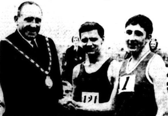 Councillor G. W. Sealey congratulates Ron Hill (Bolton Utd Harriers) after winning Pembroke 20 with Brian Woolford (Wallasey AC) who was second
