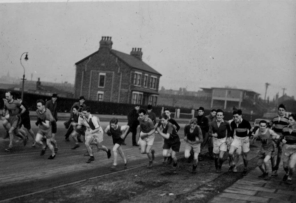 Race on Leasowe Road 1947 Club Christmas Handicap written on the back but Centenary research says 1946 - far left is John Edwards, farthest left spectator is Frank Ledward. Spectator with hat and spectacles is Geroge Mason. Runners on the right are Dennis Dickinson, Tony Dickinson and Denis Kelly