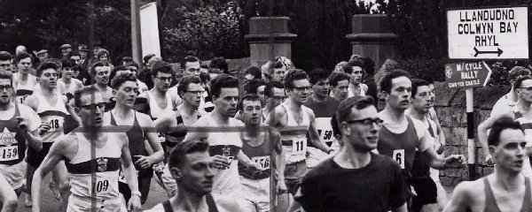 Competitors in the St. Asaph to Rhyl road race on Saturday jostle for positions at the mass start outside the Old Deanery, St. Asaph. The event is now the biggest road race in Wales, and attracts record numbers of runners. The winner was Ron Hill of Bolton.