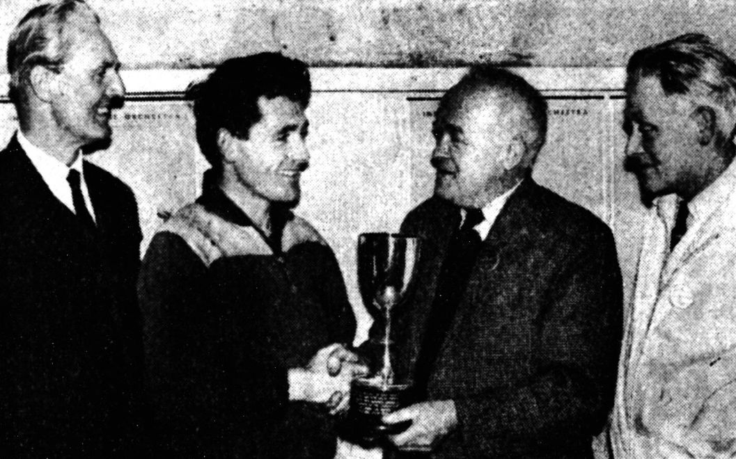 Ron Barlow of Wallasey Athletic Club receiving the Daily Post and Echo Trophy from W. Poynor, president of Waterloo Harriers, for running the fastest lap in round-the-houses relay road race at Crosby last night. Looking on are Mr M. Butkin (chairman of Waterloo Harriers), left and Mr B. P. Cory (treasurer).